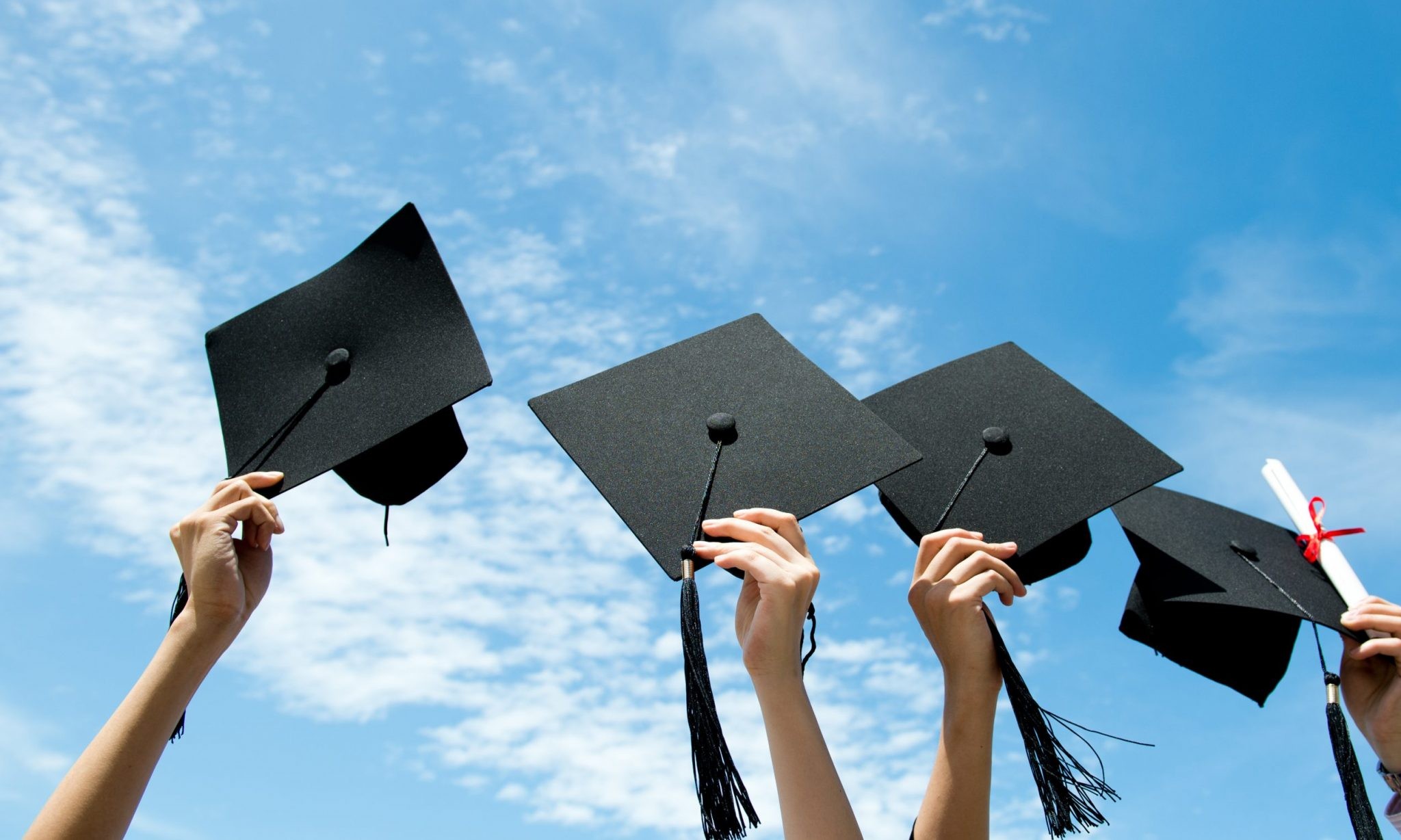 graduates throwing their hats